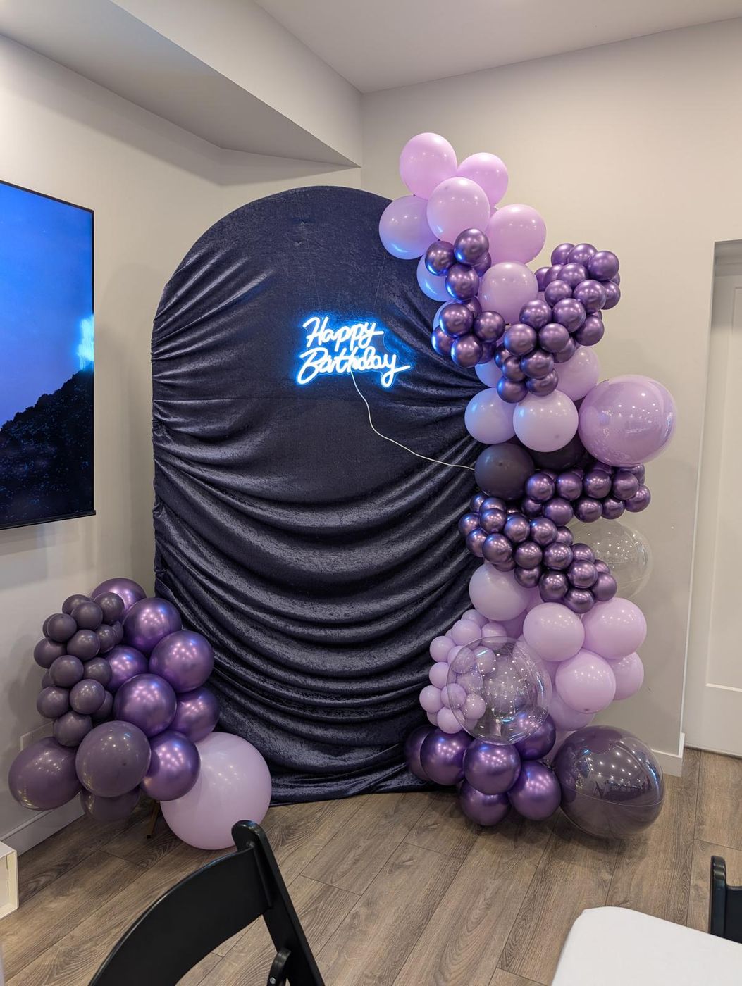 Purple arch backdrop with neon sign and pedestal